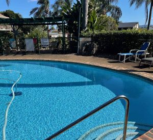 A blue swimming pool with chairs around it located at The View Hotel. (Commercial Concrete Pool)
