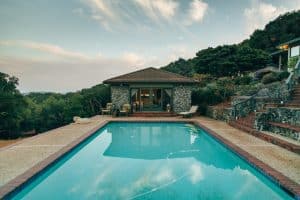 a swimming pool with steps leading up to a house.